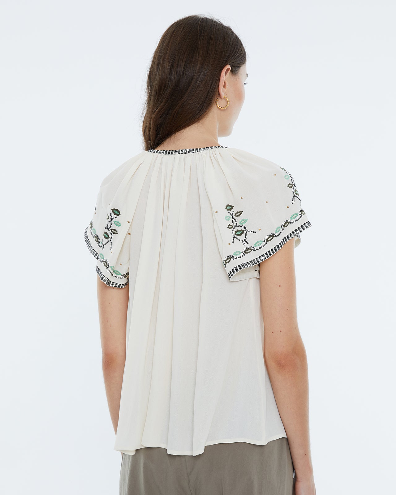 Blusa de mujer, manga corta y bordados florales.