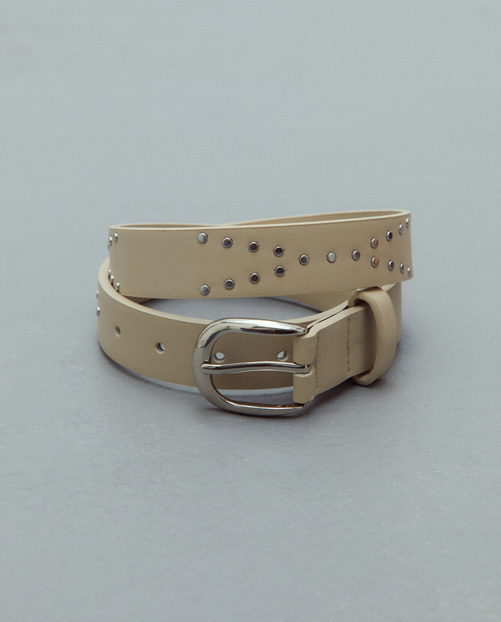 Cinturón hebilla redonda con tachas piel ecológica.