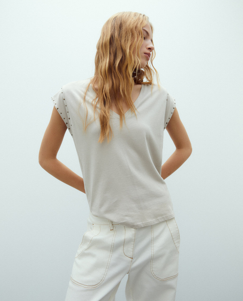 Camiseta de mujer cuello pico y tachas sisa