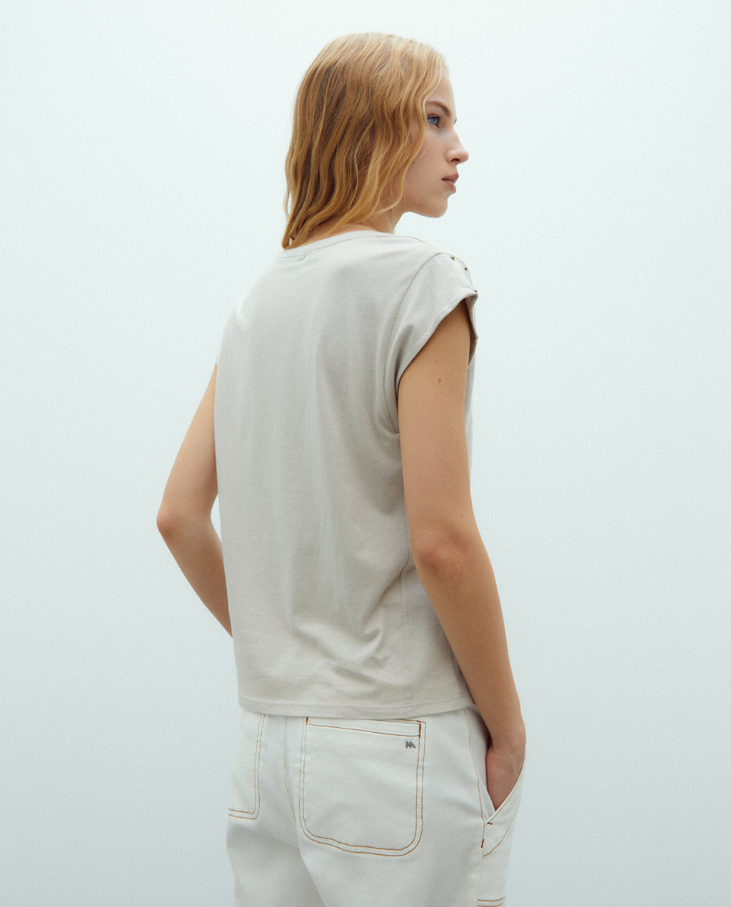 Camiseta de mujer cuello pico y tachas sisa