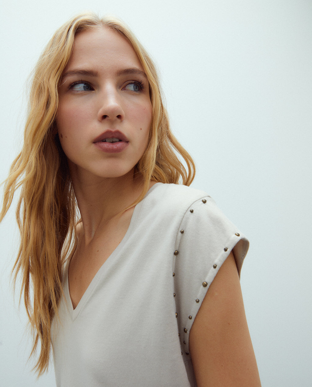 Camiseta de mujer cuello pico y tachas sisa